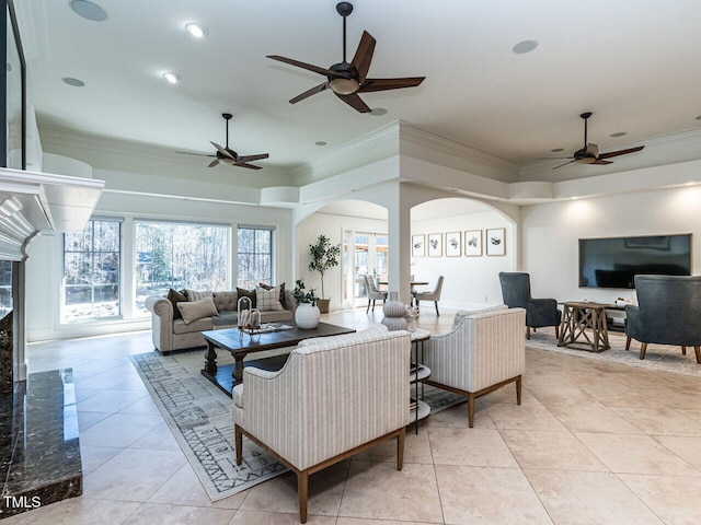 living room with crown molding, a fireplace, and light tile patterned floors