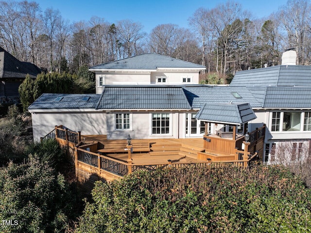 back of house featuring a wooden deck and a hot tub