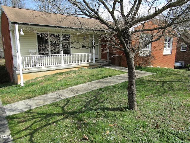 ranch-style house with a front yard and covered porch