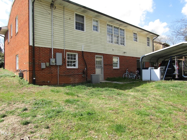 back of property featuring a yard, central AC, and brick siding