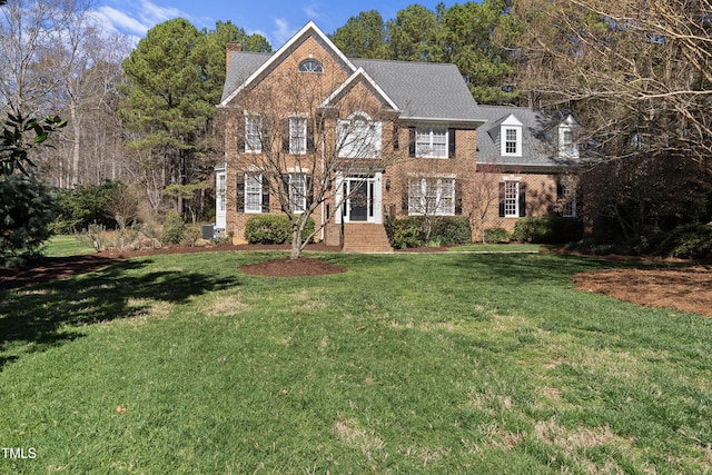 colonial home with brick siding and a front lawn