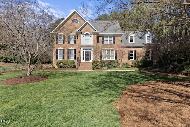 view of front of house with a front yard and brick siding