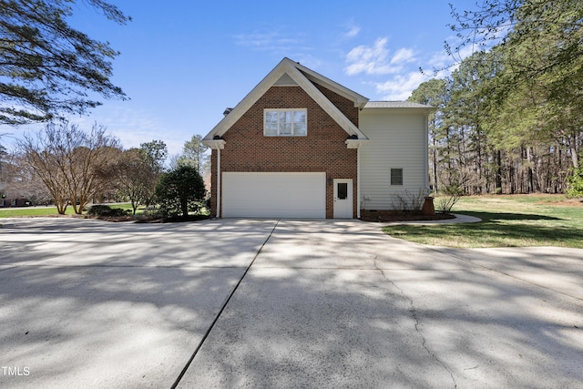 view of property exterior with an attached garage, brick siding, driveway, and crawl space