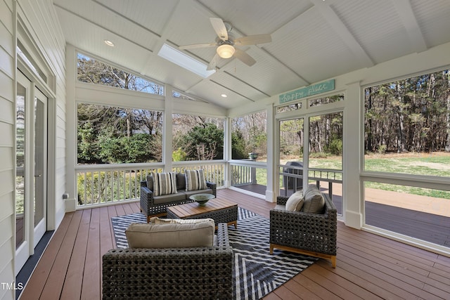 sunroom with a healthy amount of sunlight, vaulted ceiling with beams, and a ceiling fan