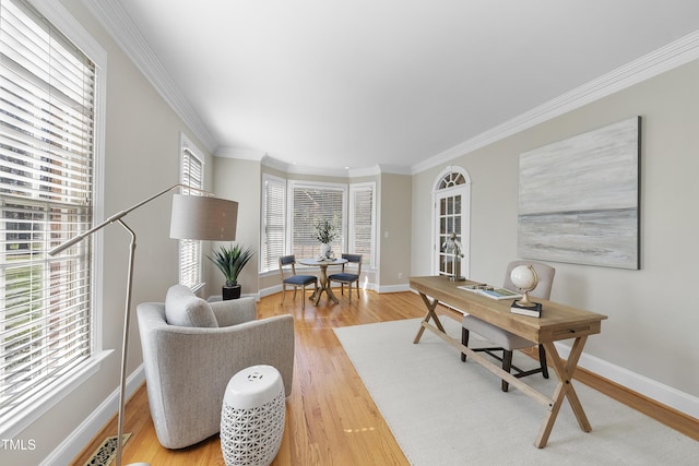 office area featuring baseboards, light wood finished floors, and ornamental molding