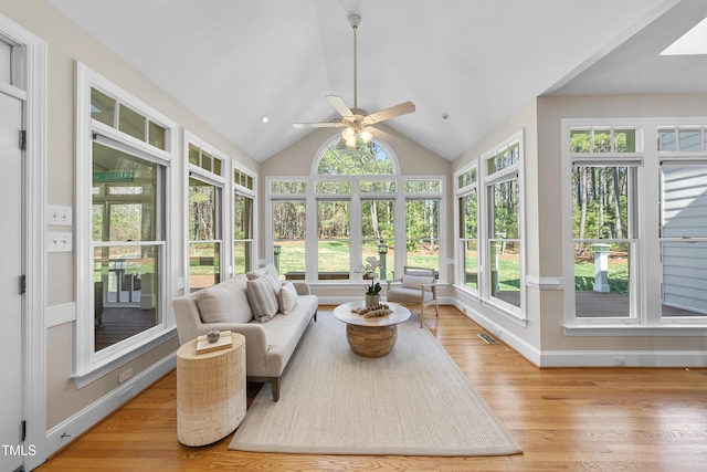 sunroom / solarium featuring lofted ceiling with skylight, a ceiling fan, and visible vents