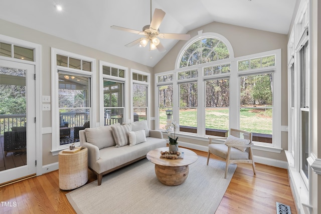 sunroom / solarium featuring vaulted ceiling, a ceiling fan, and visible vents