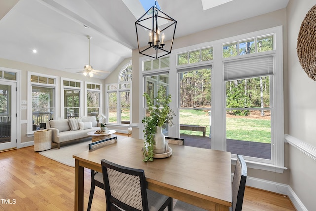 sunroom with ceiling fan with notable chandelier, vaulted ceiling, and a healthy amount of sunlight