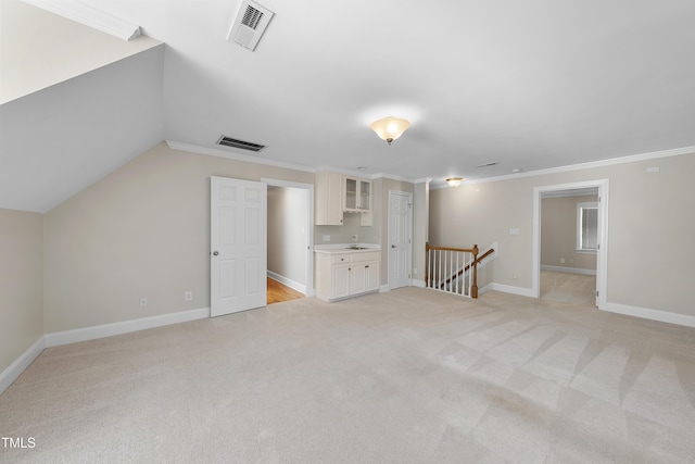 additional living space with light carpet, visible vents, baseboards, and vaulted ceiling