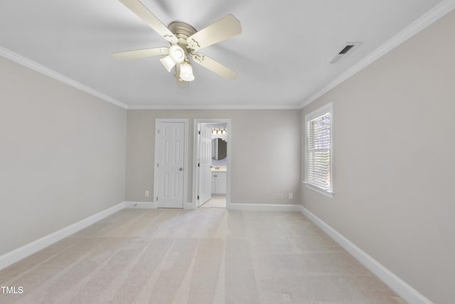 empty room featuring visible vents, baseboards, and crown molding