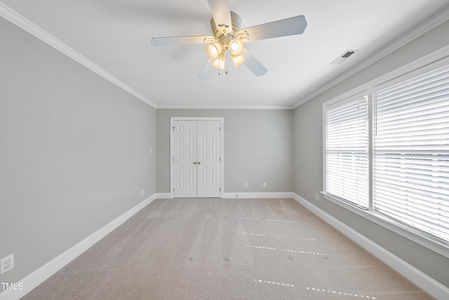 unfurnished room featuring visible vents, baseboards, ceiling fan, ornamental molding, and light carpet