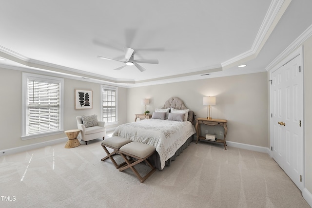 bedroom with ornamental molding, a ceiling fan, a tray ceiling, carpet flooring, and baseboards