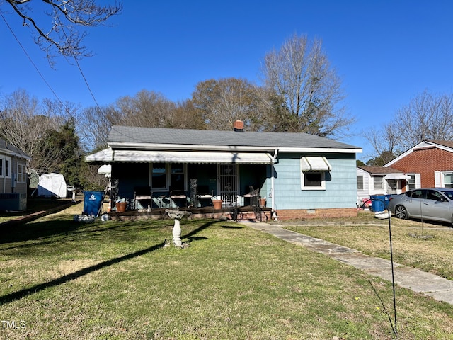 view of front of property featuring a front yard, central AC unit, and covered porch