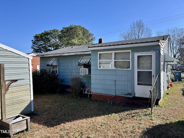 rear view of house featuring cooling unit and a lawn