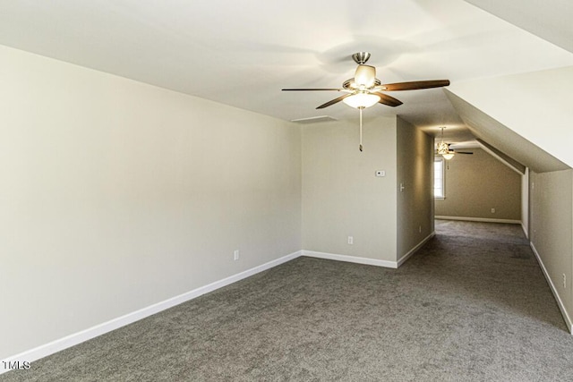 additional living space featuring lofted ceiling, dark carpet, and ceiling fan