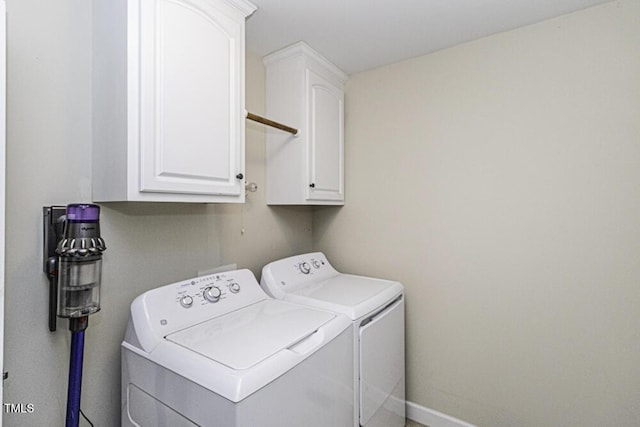 washroom featuring cabinets and washing machine and clothes dryer