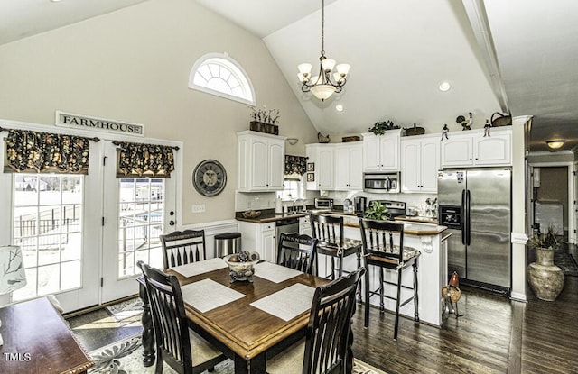 dining room with an inviting chandelier, dark hardwood / wood-style flooring, and high vaulted ceiling