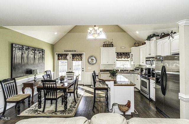 kitchen with white cabinetry, appliances with stainless steel finishes, a chandelier, and a kitchen island