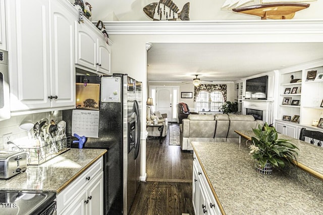 kitchen with stainless steel refrigerator with ice dispenser, dark hardwood / wood-style flooring, white cabinets, ceiling fan, and backsplash