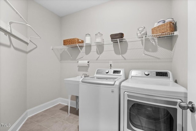 clothes washing area with washer and dryer and light tile patterned floors