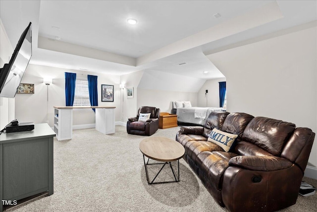 living room featuring light colored carpet and a raised ceiling