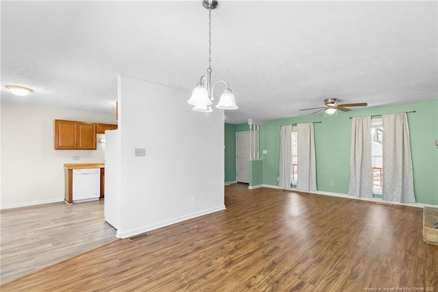 unfurnished living room with ceiling fan with notable chandelier and light wood-type flooring