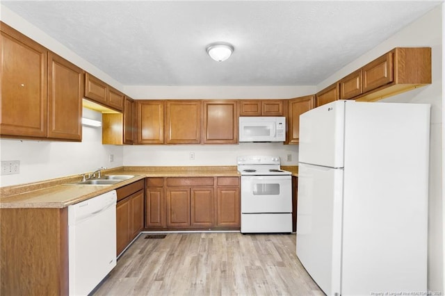 kitchen featuring sink, white appliances, and light hardwood / wood-style floors