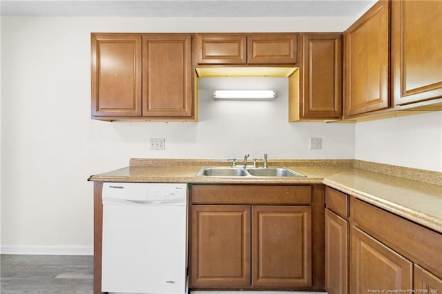 kitchen with dark wood-type flooring, dishwasher, and sink