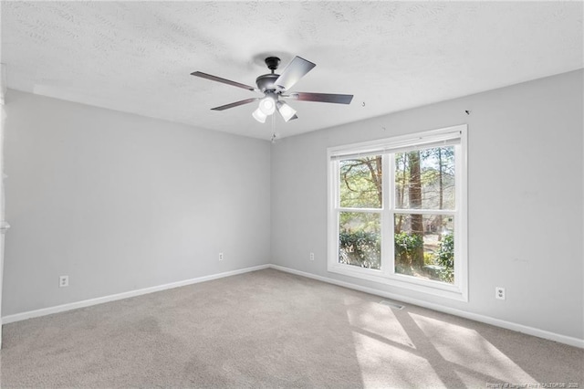 carpeted spare room featuring ceiling fan and a textured ceiling