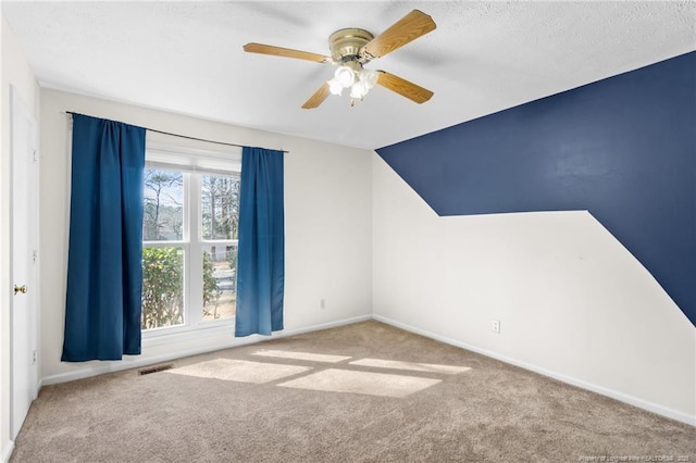 additional living space with ceiling fan, lofted ceiling, carpet floors, and a textured ceiling