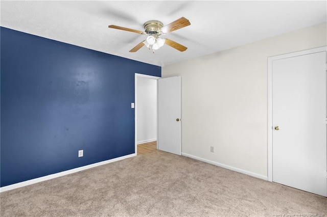 unfurnished bedroom featuring ceiling fan and light carpet