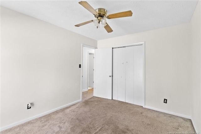 unfurnished bedroom with ceiling fan, a closet, light carpet, and a textured ceiling