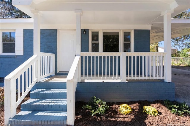 view of exterior entry with a porch