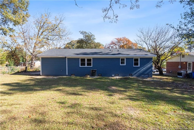 rear view of property featuring central AC and a lawn