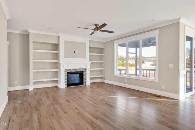 unfurnished living room with ornamental molding, ceiling fan, a fireplace, and light hardwood / wood-style flooring