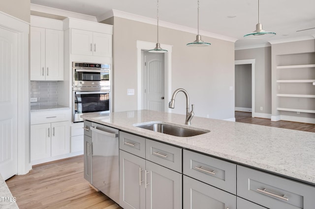 kitchen with pendant lighting, stainless steel appliances, sink, and gray cabinetry