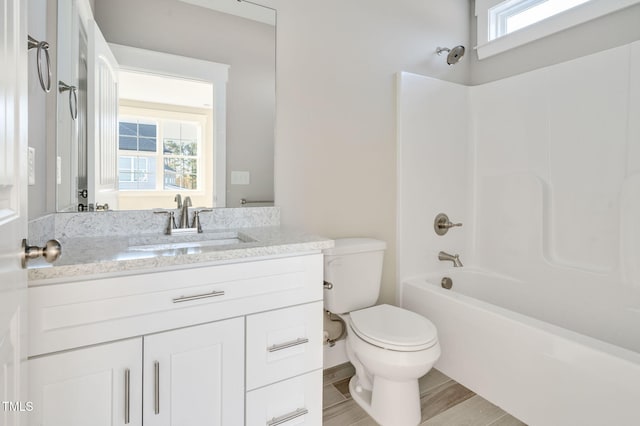 full bathroom with vanity, wood-type flooring,  shower combination, and toilet