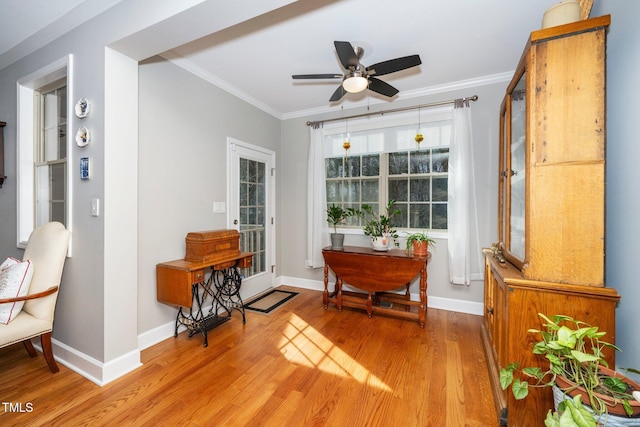 living area with light wood-style flooring, ornamental molding, and baseboards