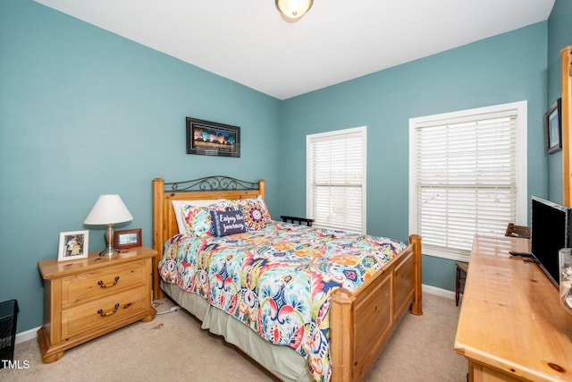 bedroom with light colored carpet and baseboards