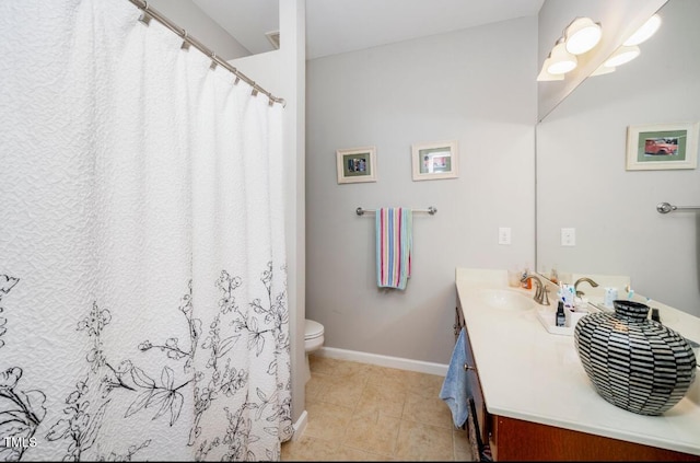 bathroom featuring tile patterned flooring, toilet, vanity, and baseboards