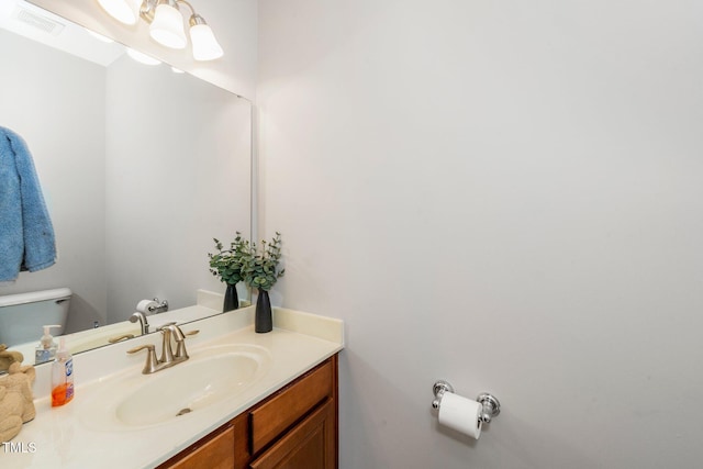 bathroom with visible vents, vanity, and toilet