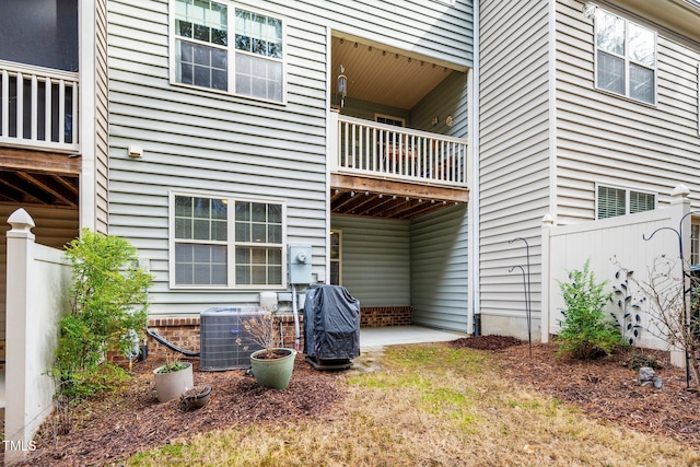 rear view of property featuring a patio area, fence, and central air condition unit