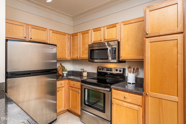 kitchen featuring appliances with stainless steel finishes, dark stone counters, ornamental molding, light tile patterned floors, and light brown cabinets