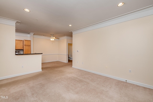 carpeted spare room featuring ornamental molding and ceiling fan