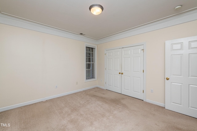 unfurnished bedroom featuring a closet, ornamental molding, and light carpet