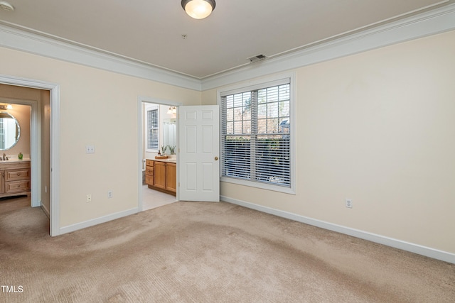 unfurnished bedroom with light carpet, connected bathroom, ornamental molding, and sink