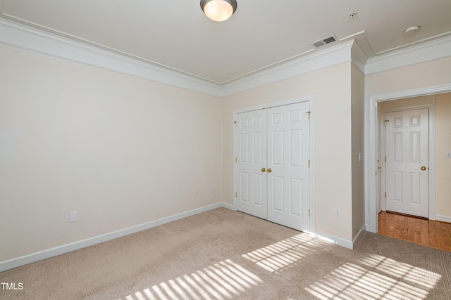 unfurnished bedroom featuring ornamental molding, carpet, and a closet