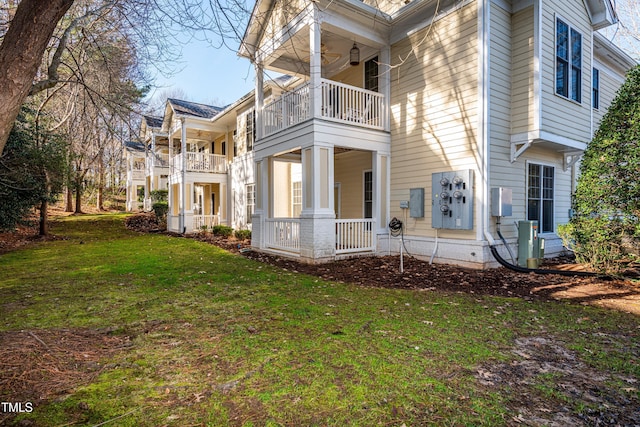 view of side of home with a balcony and a lawn