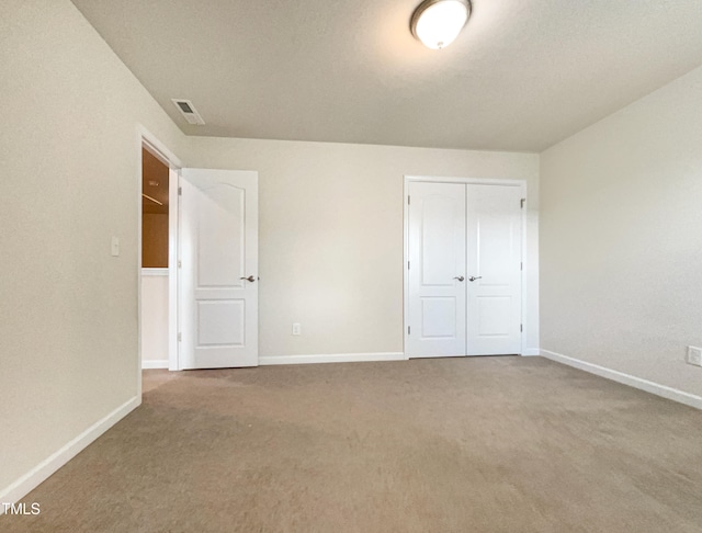 unfurnished bedroom featuring carpet flooring and a closet