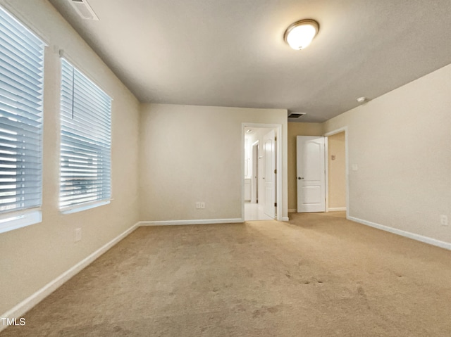 unfurnished bedroom featuring ensuite bathroom and carpet flooring